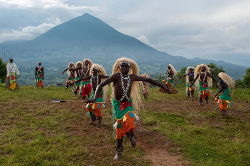 Intore dancers with a Virunga volcano behind them